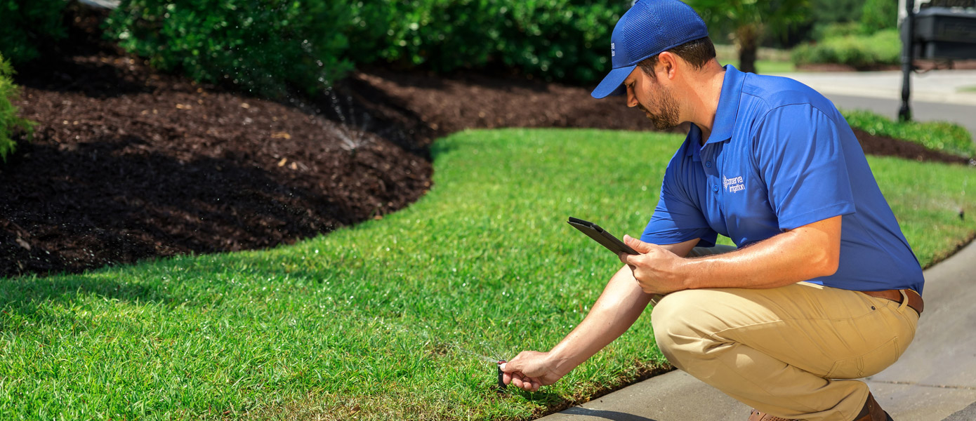 Irrigation technician adjusting sprinkler